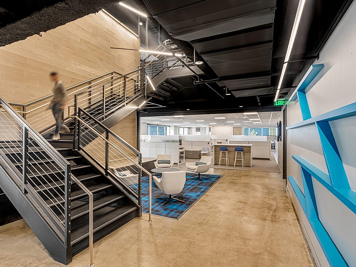 Someone coming down an open staircase in the lobby of TrueSports